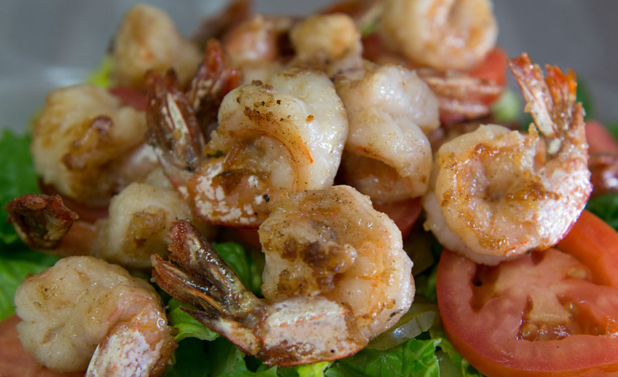Grilled shrimp prepared NOLA style, with salad and tomatoes